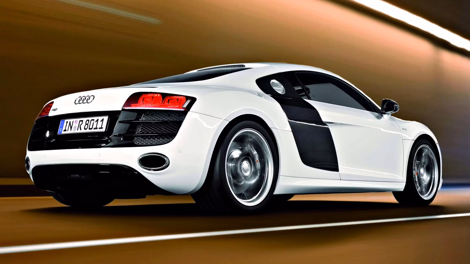 Rear three-quarter of a first-gen Audi R8 V10 showing the wider rear diffuser and exhaust outlets