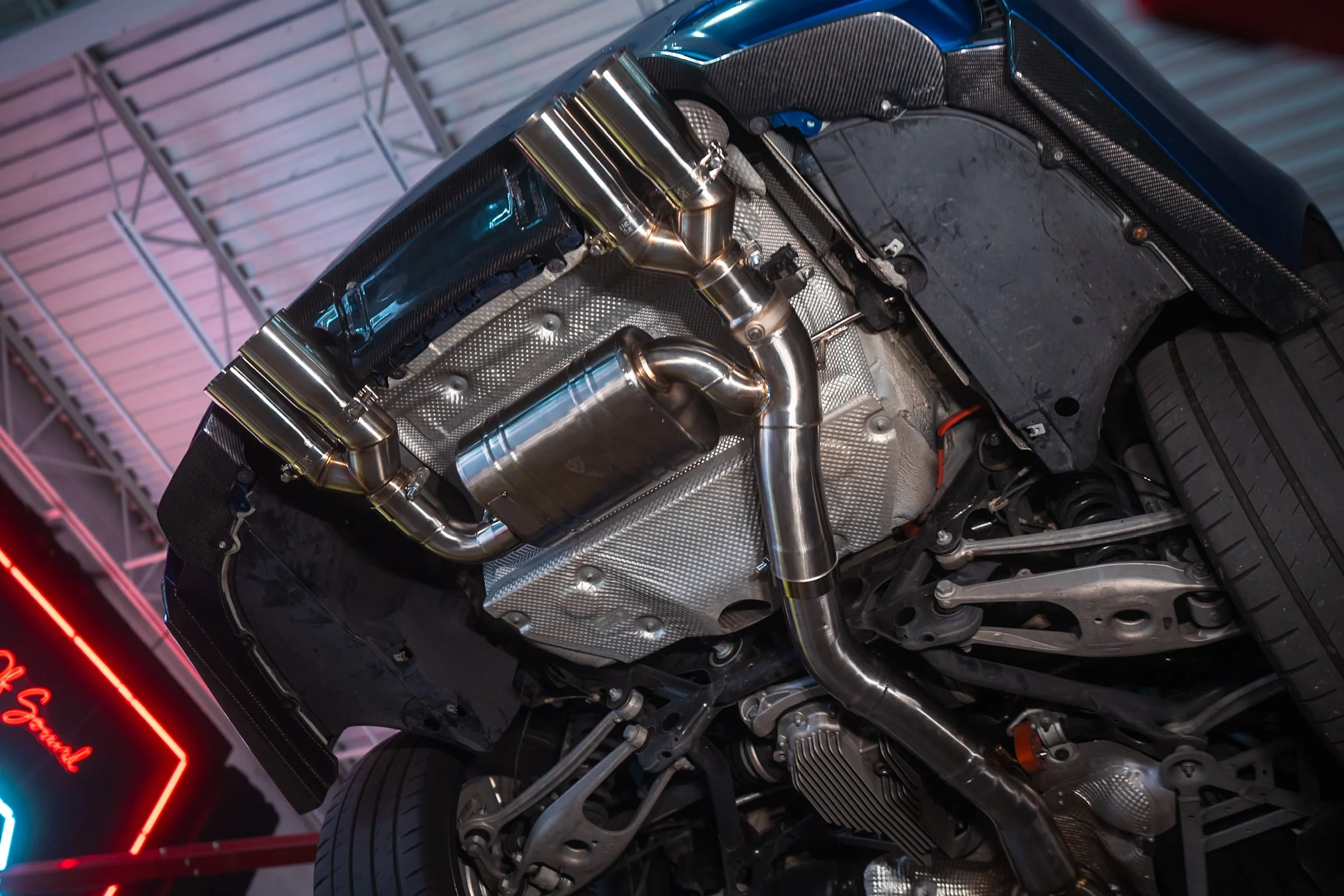 Undercarriage view of a BMW M4 F82 showing an equal-length midpipe exhaust section installed