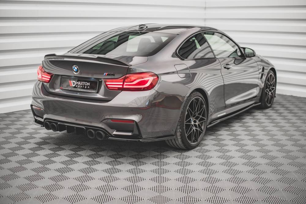 Rear view of a BMW M4 F82 showing wide stance, quad exhaust tips, diffuser, and L-shaped tail lights