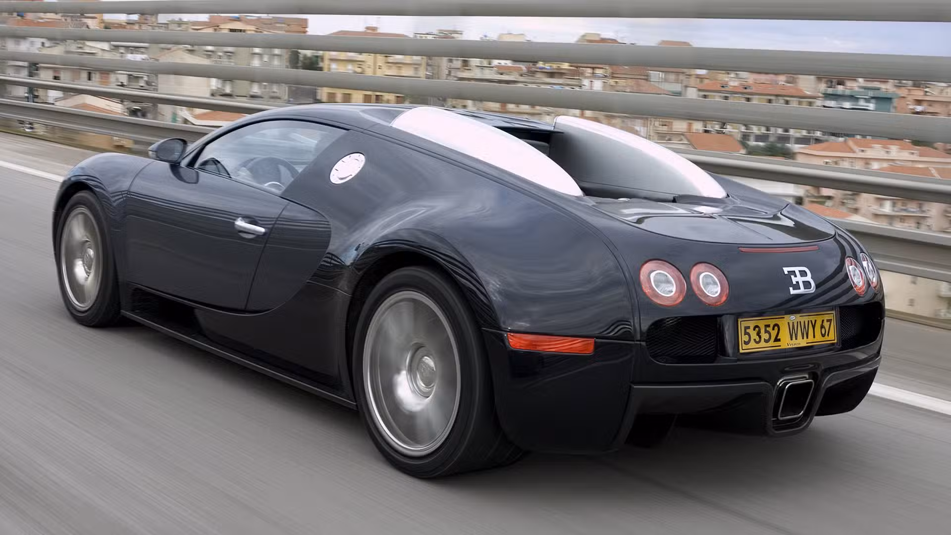Rear view of a Bugatti Veyron showing wide rear haunches, central exhaust outlets, and distinctive taillights