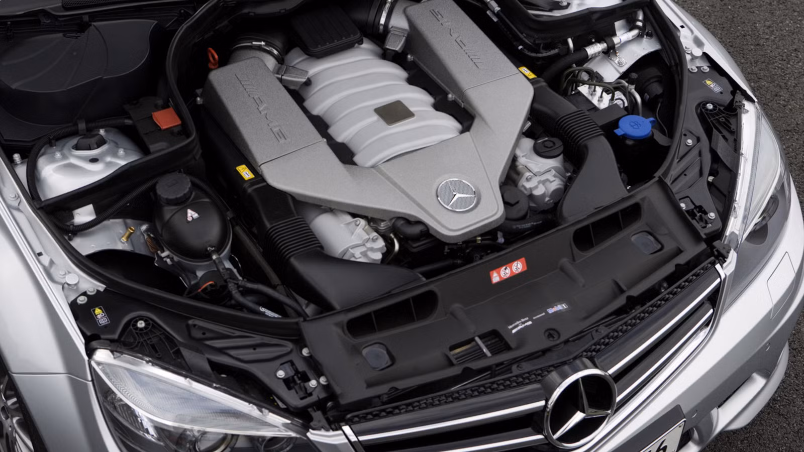 Engine bay shot of a W204 C63 AMG showing the AMG V8 cover and intake layout
