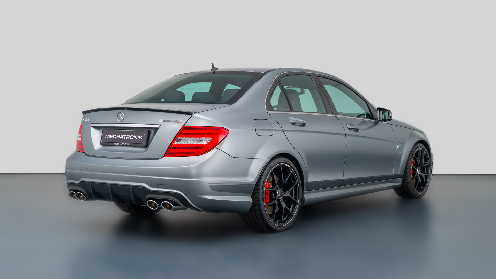 Rear 3/4 shot of a W204 C63 AMG clearly showing the quad exhaust tips and rear diffuser styling