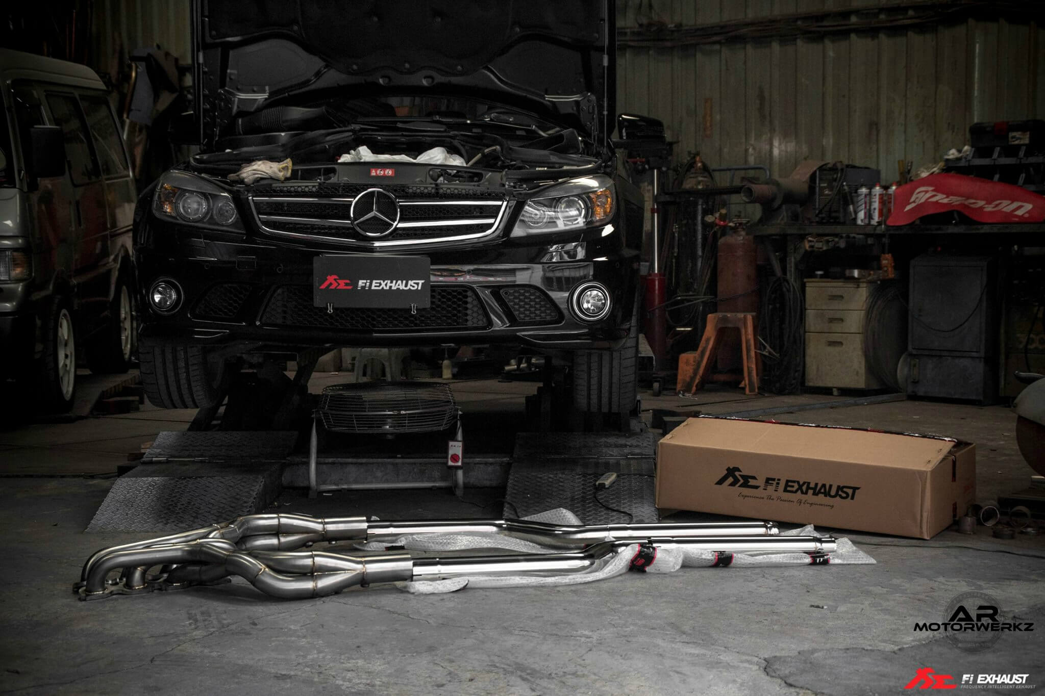 Clean workshop/service photo of a Mercedes-AMG V8 being worked on (no gore, no mess), implying maintenance/inspection