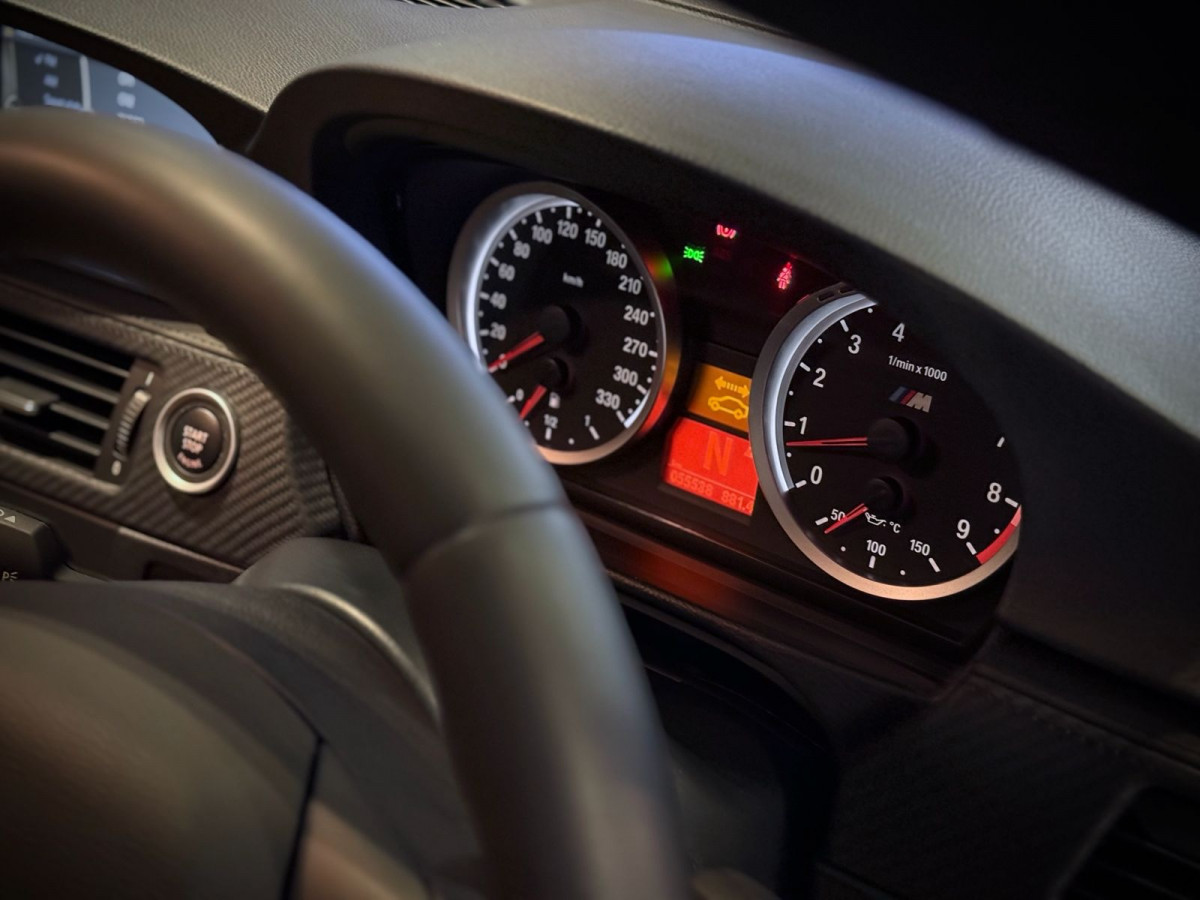 Interior shot focusing on the E9X M3 gauge cluster with tachometer near the high rpm range