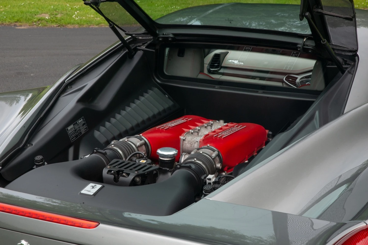 Ferrari 458 Italia engine visible through the rear glass showing the naturally aspirated V8 layout