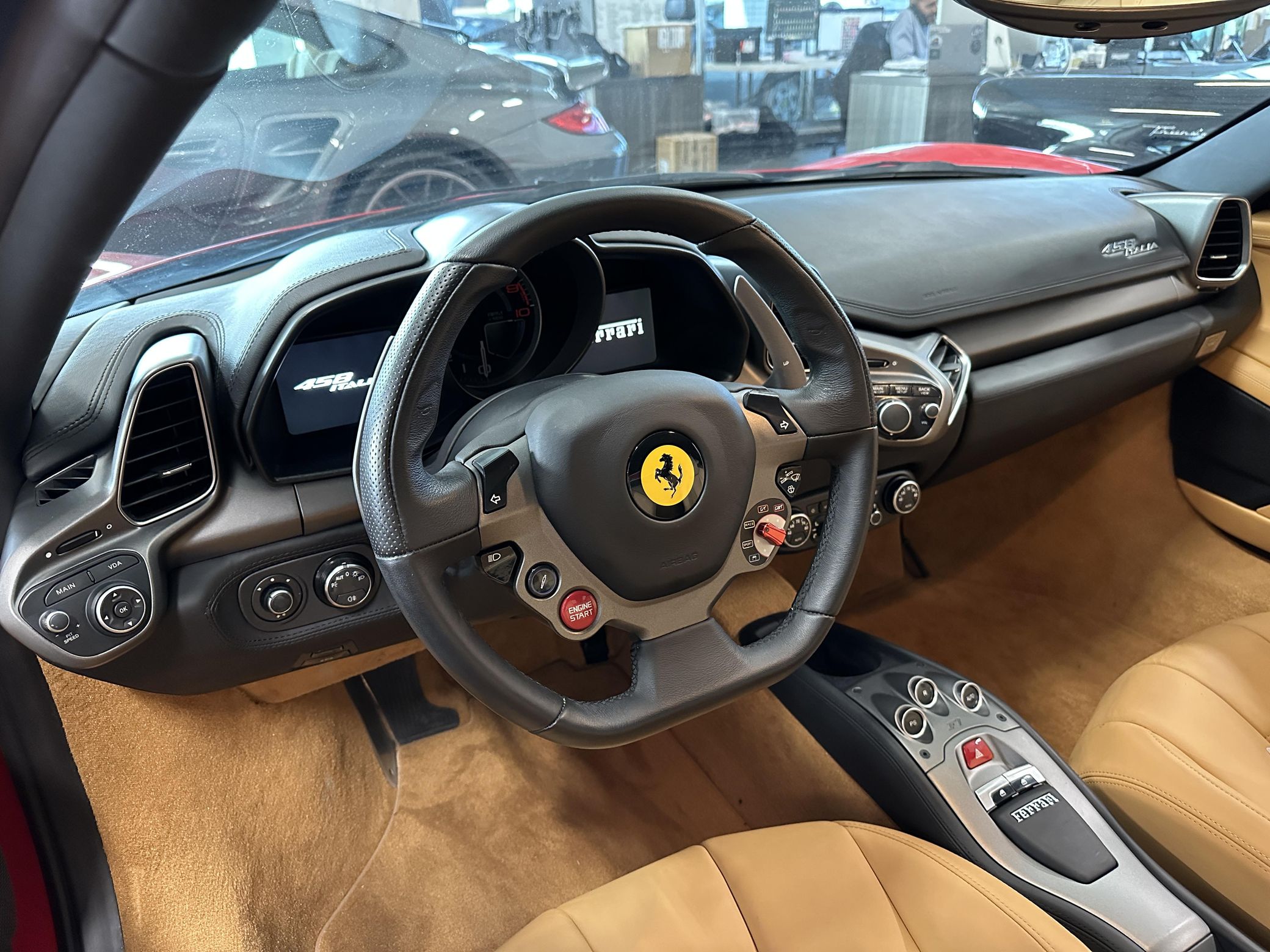 Interior shot of a Ferrari 458 Italia steering wheel showing the manettino dial and integrated controls