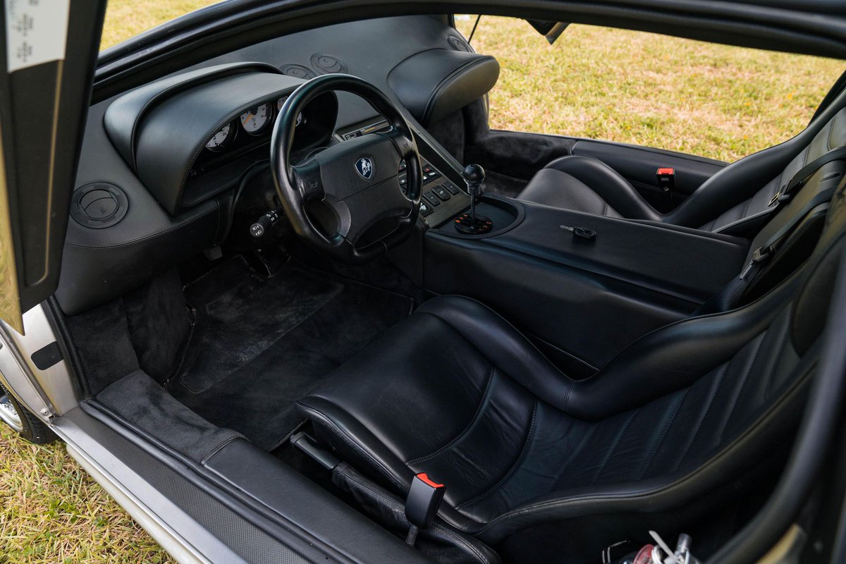 Interior cockpit view of a Lamborghini Diablo showing low windshield, wide dash, and tight footwell