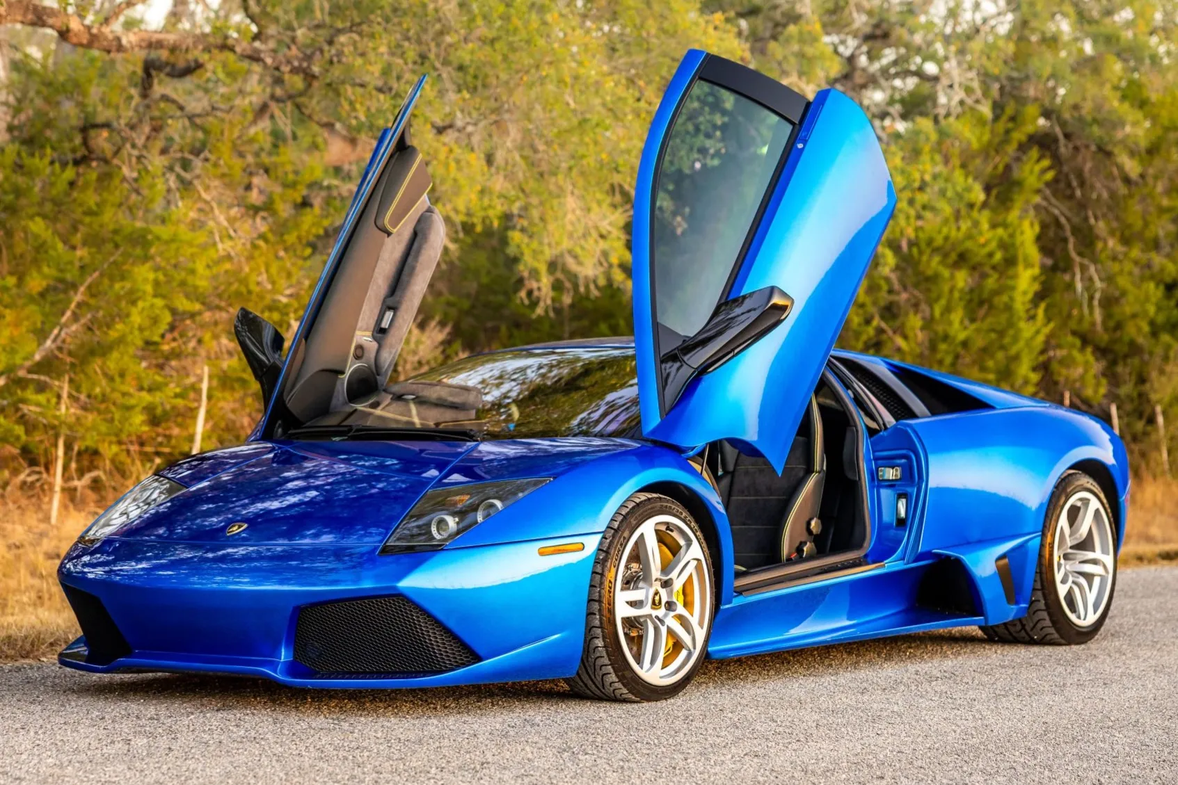 Side profile shot of a Murciélago with scissor doors open, showing how the door shape changes the silhouette