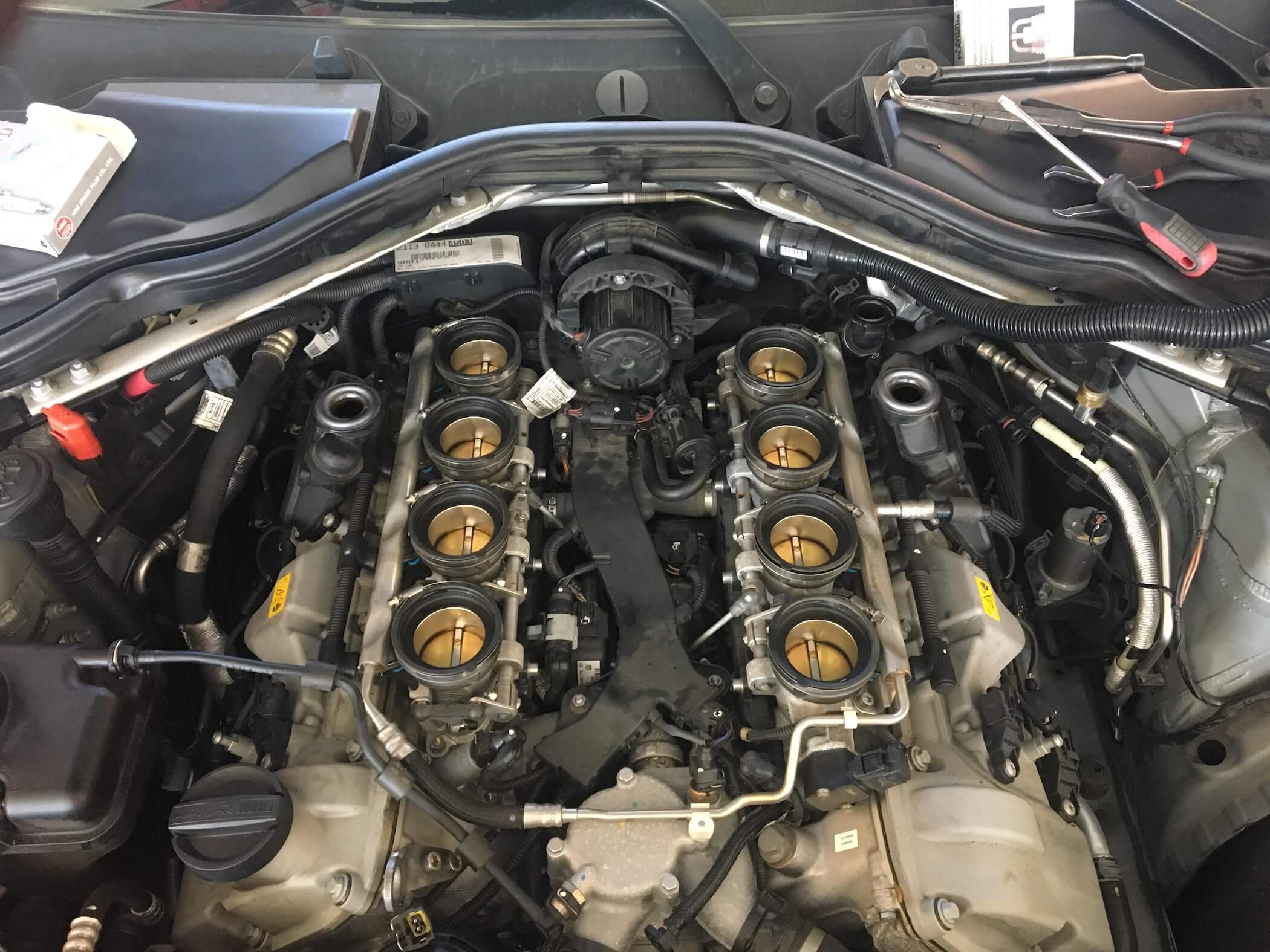BMW S65 V8 engine bay showing the intake plenum and individual throttle body layout